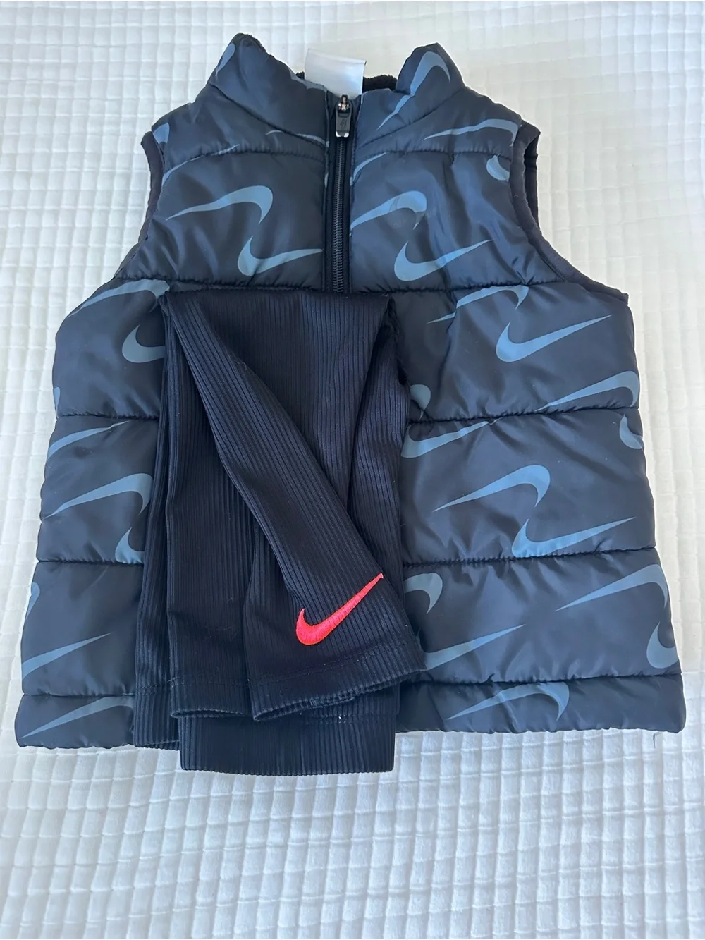 Nike Black Puffer Vest with Light Blue Swoosh and Black Leggings
